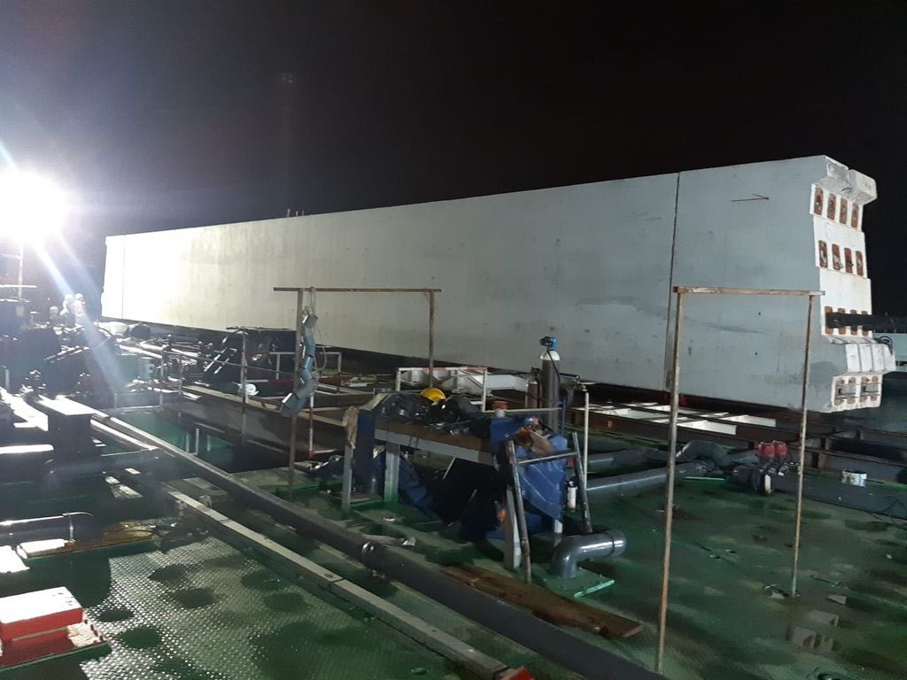 Poutre béton sur la barge, de nuit