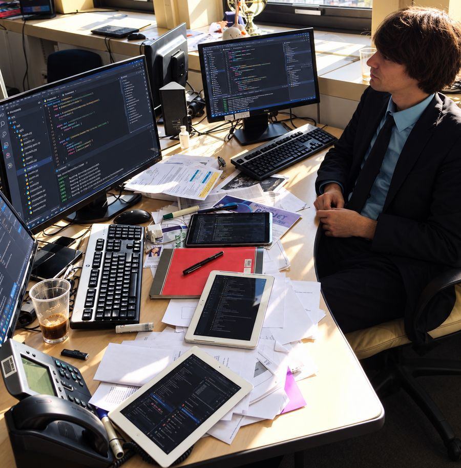 Fabien à son bureau au Crédit Agricole, entouré d’écrans, de tablettes et de papiers